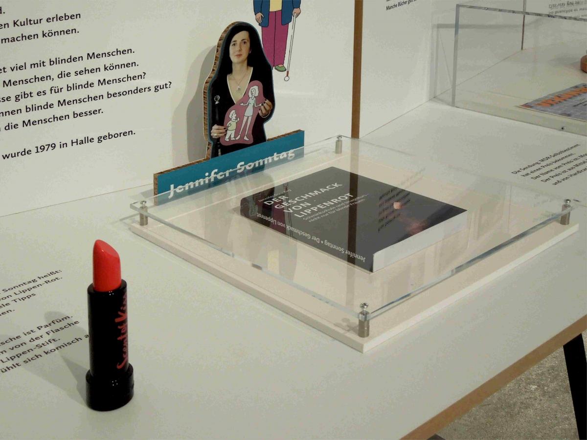 Detail Ausstellungstisch mit Parfümflakon, Buch und Foto