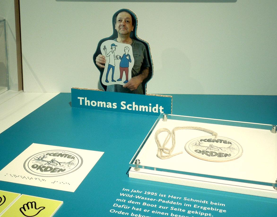 Detail Ausstellungstisch mit Kenterorden, daneben als Tastobjekt und Foto von Thomas Schmidt